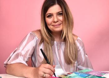 White woman in a shiny shirt, writing