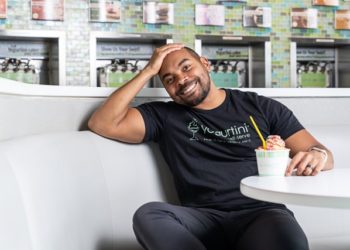 black man sitting at a restaurant table with Yogurt