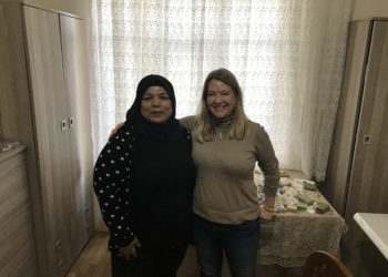 Blonde woman and woman in Arab attire, side by side