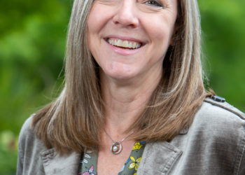 woman in silver jacket smiling