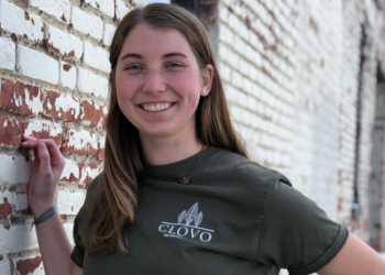 woman standing next to a brick wall