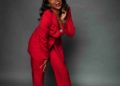 black woman in a red pantsuit, laughing