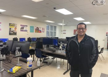 Man in black standing in a technology classroom